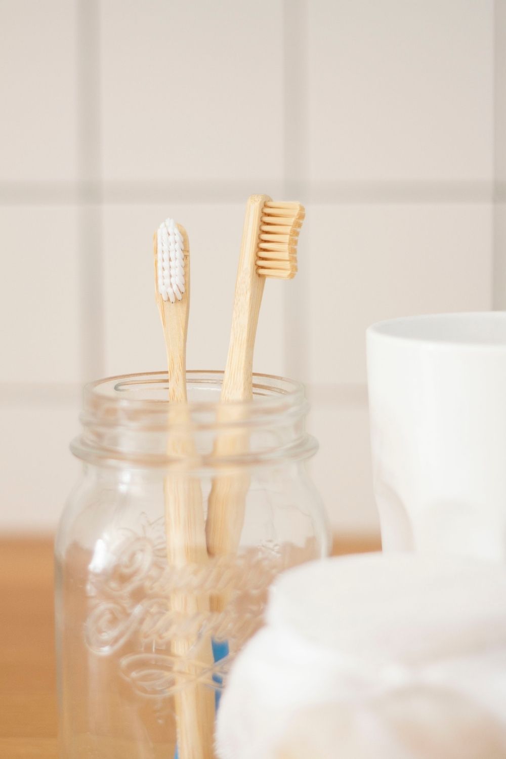 Two bamboo toothbrushes in mason jar